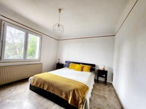 - une chambre avec un lit doté d'oreillers jaunes et d'une fenêtre dans l'établissement Villa La Chenal, à Fréjus