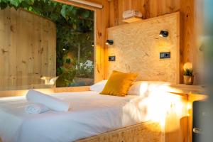sypialnia z dużym łóżkiem i oknem w obiekcie Kampaoh Calella de Palafrugell w mieście Palafrugell