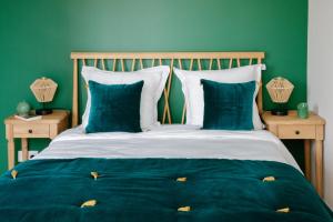 a green bedroom with a bed with blue sheets and pillows at Serenity chic apartment Nice center in Nice