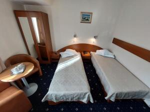 a hotel room with two beds and a table at Hotel Egreta in Tulcea