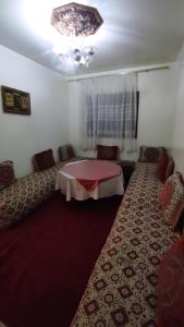 um quarto com uma mesa e cadeiras num quarto em Residence Gharnata app 11 imm I em Marraquexe