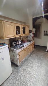 a kitchen with wooden cabinets and a stove top oven at Residence Gharnata app 11 imm I in Marrakech