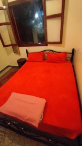 Cama roja con almohadas rojas y ventana en Residence Gharnata app 11 imm I en Marrakech