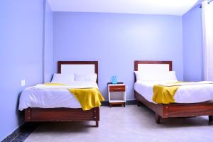 two beds in a room with blue walls at Kechei Centre in Iten