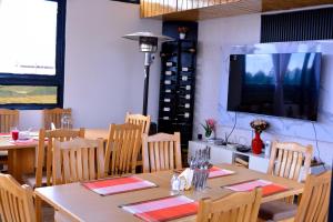 a dining room with wooden tables and a flat screen tv at Kechei Centre in Iten