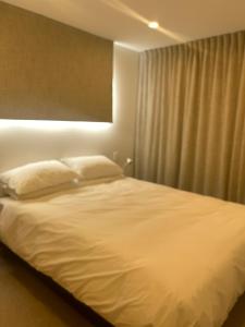 a bedroom with a white bed with a window at KOTARE – Stunning Kaiteriteri Holiday Home in Kaiteriteri