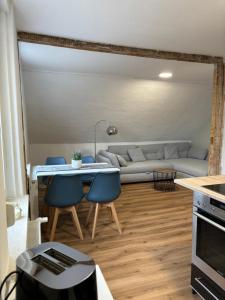 a living room with a couch and a table and chairs at NEU! Canossablick Bad Harzburg Inklusive Bettwäsche in Bad Harzburg +3 photos