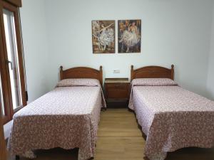 een kamer met twee bedden en een foto aan de muur bij Casa de Pueblo en Ossa de Montiel in Ossa de Montiel