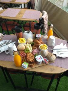 uma mesa com uma bandeja de alimentos para o pequeno-almoço e sumo de laranja em Merry's House em Lagos