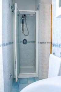 een douche met een glazen deur in de badkamer bij A Casa Romano in Ravello