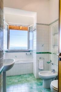 een badkamer met een wastafel, een bad en een toilet bij A Casa Romano in Ravello