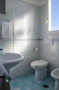 een witte badkamer met een toilet en een wastafel bij A Casa Romano in Ravello