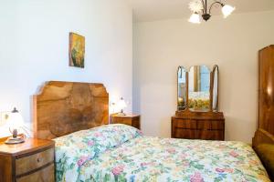 een slaapkamer met een bed, een dressoir en spiegels bij A Casa Romano in Ravello