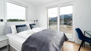 a bedroom with a bed and a large window at Apartamenty Sun & Snow Panorama Karkonoszy in Karpacz