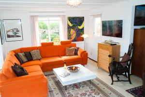 a living room with an orange couch and a table at Bijzonder chalet An der Marina met sauna in Anjum