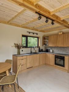 - une cuisine avec des placards en bois, une table et des chaises dans l'établissement Sankakkei 2 - Lewy Brzeg Narwi, à Burlaki