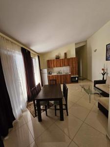 a living room with a dining table and a kitchen at Afrodita Apartments 2 in Sinemorets