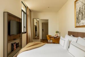 a hotel room with a bed and a television at Casa de las Artes, member of Meliá Collection in Madrid