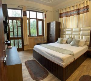 una camera con un grande letto di Maa Tara Anchal Cottage By BYOB Hotels a Shimla
