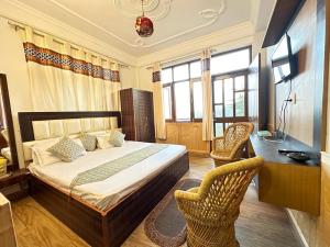 Maa Tara Anchal Cottage By BYOB Hotels في شيملا: غرفة نوم بسرير ومكتب وكراسي