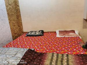 Un dormitorio con una cama con una manta de flores. en Kadiya dharamshala, en Mathura