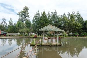 un padiglione nel mezzo di un corpo d'acqua di Hilltop Camp by TwoSpaces, Lembang a Lembang