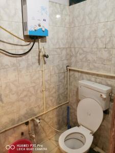 een kleine badkamer met een toilet en een televisie bij Kadiya dharamshala in Mathura