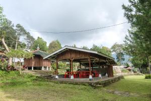 a pavilion with a picnic table in a park at Hilltop Camp by TwoSpaces, Lembang in Lembang