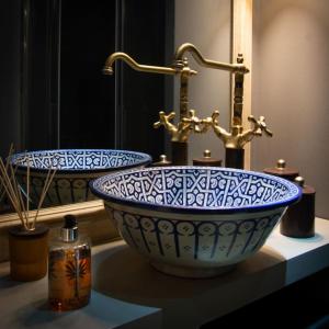 a bathroom with a blue and white sink and a mirror at Casa Bellezia- design e storia nel cuore di Torino in Turin