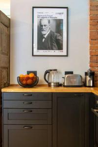 a kitchen counter with a bowl of oranges and a picture at Casa Bellezia- design e storia nel cuore di Torino in Turin +37 photos