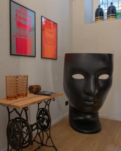 a black mask sitting next to a table at Casa Bellezia- design e storia nel cuore di Torino in Turin