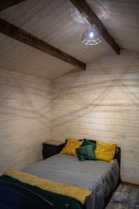 1 dormitorio con 1 cama en una habitación de madera en Jausa metsamaja en Yauza