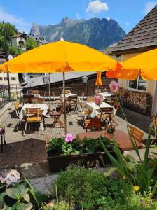 a patio with tables and chairs and a yellow umbrella at Himmel in Ebensee
