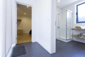 a bathroom with a walk in shower and a glass shower stall at Quinta das Rosas Villas in Ribeira Grande