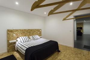 a bedroom with a bed and a stone wall at Quinta das Rosas Villas in Ribeira Grande