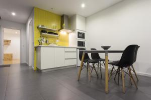 a kitchen with a table and black chairs at Quinta das Rosas Villas in Ribeira Grande
