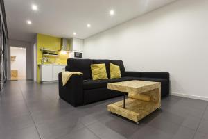 a living room with a black couch and a table at Quinta das Rosas Villas in Ribeira Grande