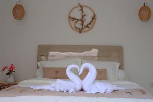 zwei weiße Schwäne auf einem Bett in der Unterkunft Puspa Villa in Kerobokan