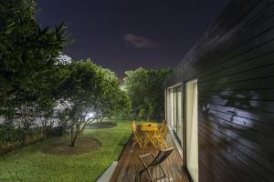 a deck with a picnic table on the side of a house at Quinta das Rosas Villas in Ribeira Grande
