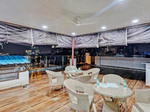 a restaurant with tables and chairs and a view of the city at The Grand Hotel Akshay in Gurgaon
