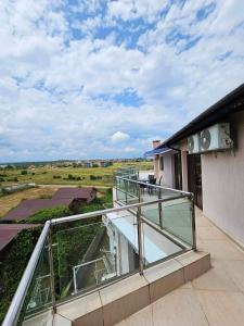 een balkon van een huis met uitzicht op een veld bij Afrodita Apartments 2 in Sinemorets