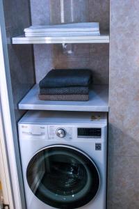 a washer and dryer on a shelf with towels at Стильная и уютная двухкомнатная квартира. in Bishkek