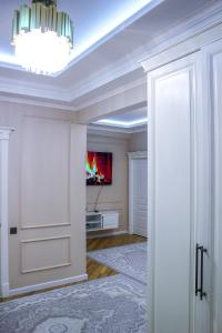 an open door into a room with a tv on the wall at Стильная и уютная двухкомнатная квартира. in Bishkek