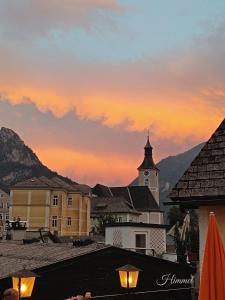 a view of a building with a clock tower at sunset at Himmel in Ebensee