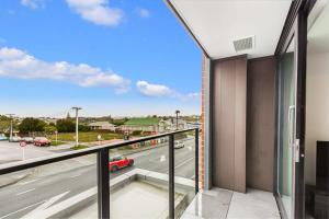 Elle comprend un balcon offrant une vue sur la rue. dans l'établissement Cozy apartment by Eden Park, à Auckland