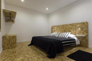 a bedroom with a bed and a stone wall at Quinta das Rosas Villas in Ribeira Grande
