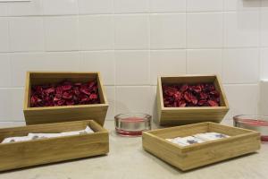 three wooden boxes filled with roses on a table at Quinta das Rosas Villas in Ribeira Grande