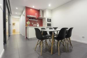 a dining room with a table and black chairs at Quinta das Rosas Villas in Ribeira Grande