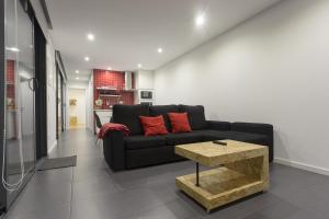 a living room with a black couch and a table at Quinta das Rosas Villas in Ribeira Grande