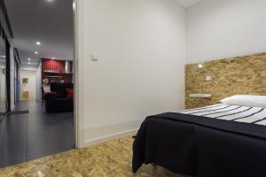 a bedroom with a bed and a living room at Quinta das Rosas Villas in Ribeira Grande